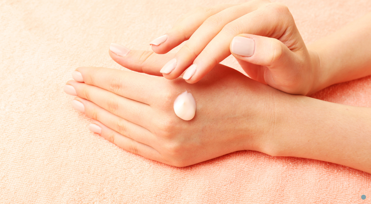 Picture of hands that look soft and supple, with woman applying lotion - after dermal filler for hands treatment