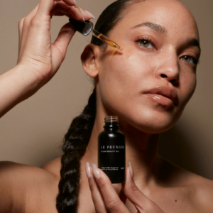 woman applying face oil to her skin 