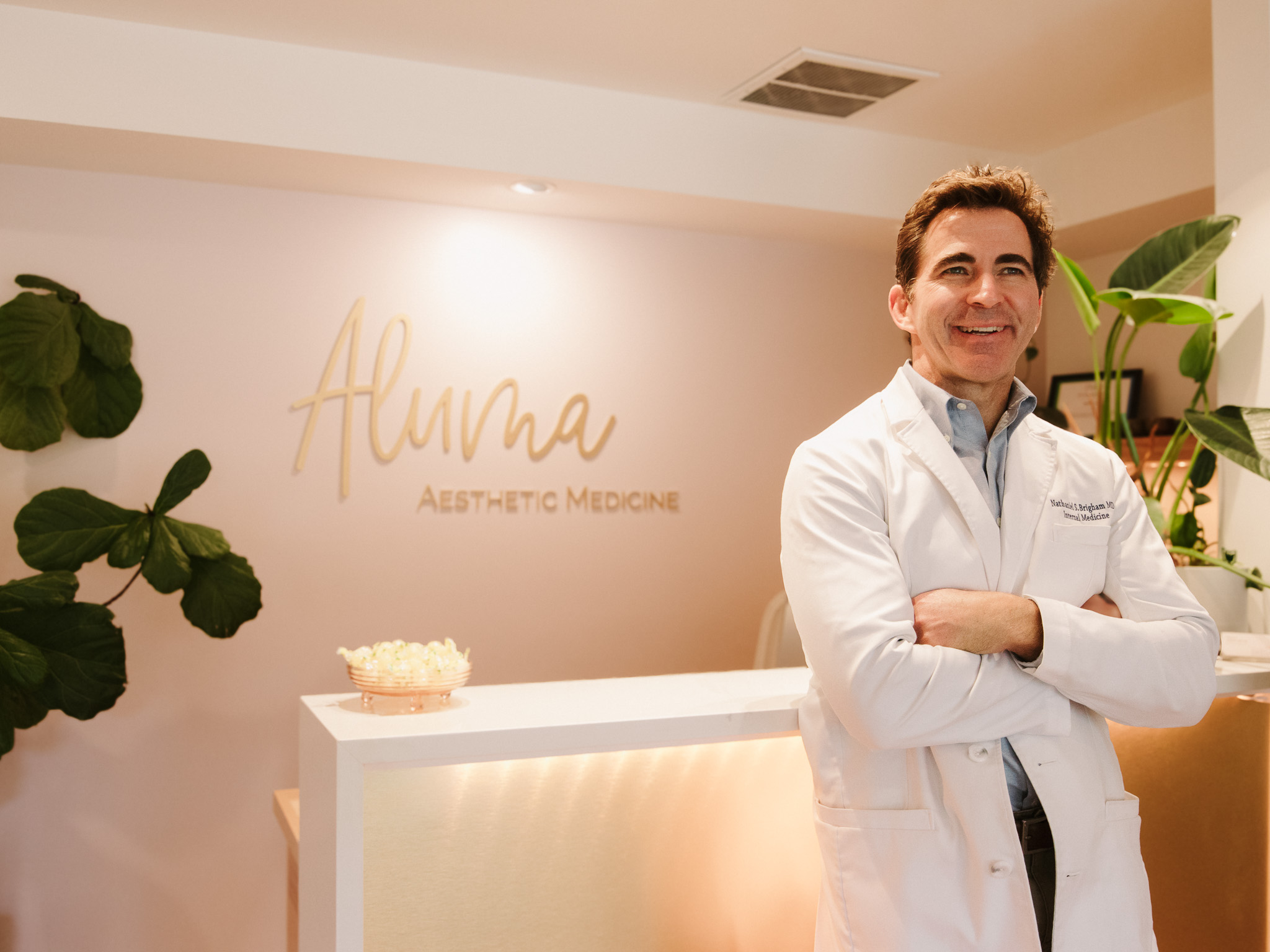 Dr. Nathaniel Brigham MD posing at the front of his aesthetic medicine clinic in Portland OR