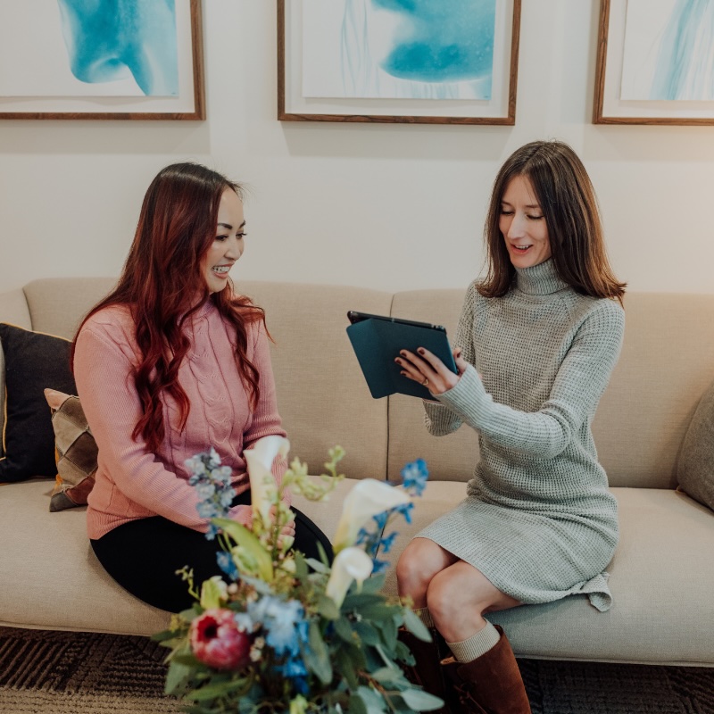 woman on couch reviewing microneedling instructions at Aluma Aesthetic Medicine in Portland, OR